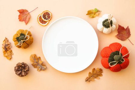 Photo for Autumn food background. Thanksgiving table. White plate and golden cutlery with decorations on color background. Flat lay. - Royalty Free Image