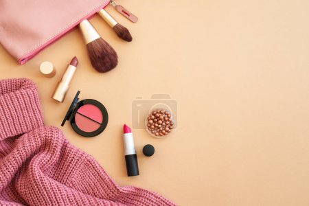 Photo for Cloth and accessories on color background. Sweater, cosmetic bag and make-up products. Flat lay image with space for text. - Royalty Free Image