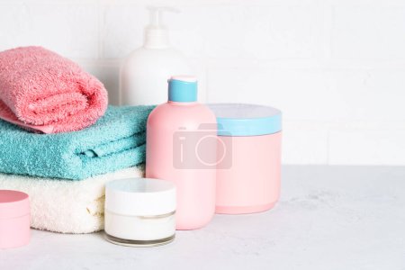 Photo for Cosmetic products and clean towels in the bathroom. Spa treatment and beauty. - Royalty Free Image