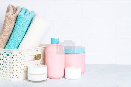 Téléchargez les photos : Produits cosmétiques et serviettes propres dans la salle de bain. Soins spa et beauté. - en image libre de droit