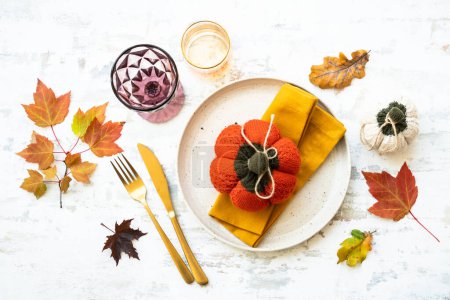 Téléchargez les photos : Table d'automne. Assiette blanche, couverts et décorations sur fond blanc. Pose plate. - en image libre de droit