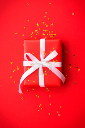 Foto de Caja regalo de Navidad, regalo rojo con cinta en fondo rojo. Imagen de laico plano. - Imagen libre de derechos