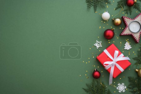 Téléchargez les photos : Cadeau de Noël et décorations rouges sur fond de couleur. Image de pose plate avec espace de copie. - en image libre de droit