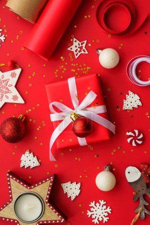 Téléchargez les photos : Noël Cadeau boîte et décorations à fond rouge. Emballage cadeau de Noël. Image de pose plate. - en image libre de droit