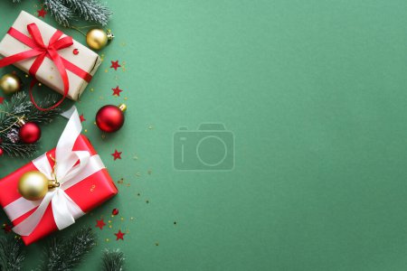 Téléchargez les photos : Cadeau de Noël et décorations rouges sur fond de couleur. Image de pose plate avec espace de copie. - en image libre de droit