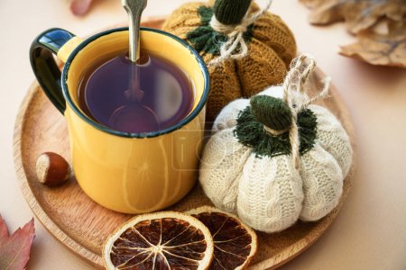 Photo for Cup of tea, spices, dry leaves, and knitted autumn decorations. Cozy autumn composition. Toned image. - Royalty Free Image