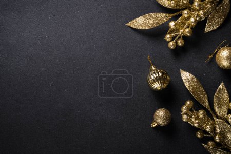 Foto de Decoraciones de oro navideño sobre fondo negro. Imagen de vista superior con espacio de copia. - Imagen libre de derechos
