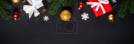 Photo for Black christmas flat lay background. Christmas fir tree with presents and holidays decorations. Long web banner format. - Royalty Free Image