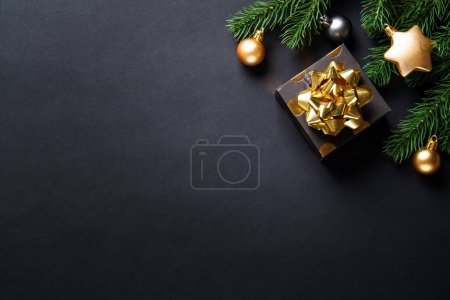 Foto de Fondo de Navidad con árbol de Navidad, caja de regalo y decoraciones navideñas. Navidad en negro y oro. - Imagen libre de derechos