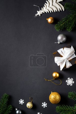 Photo for Christmas greeting card, vertical. Christmas background with white and gold holiday decorations. Flat lay with copy space at black. - Royalty Free Image