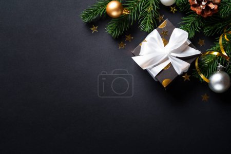 Téléchargez les photos : Fond de Noël avec arbre de Noël, boîte cadeau et décorations de vacances. Noël noir et or. - en image libre de droit