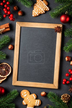 Téléchargez les photos : Biscuits au pain d'épice, épices et décorations de Noël au noir. Vue du dessus avec espace pour le texte. - en image libre de droit