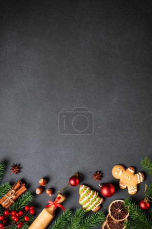 Photo for Gingerbread cookies, spices and Christmas decorations at black. Top view with space for text. - Royalty Free Image