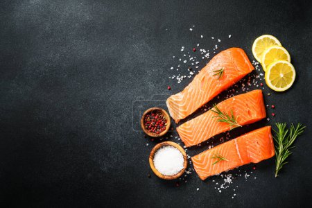 Téléchargez les photos : Filet de saumon, poisson frais cru à table noire. Vue du dessus. - en image libre de droit
