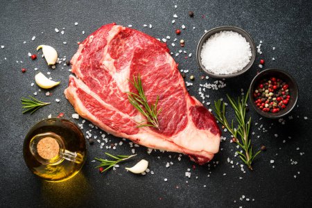Photo for Meat steak. Beef steak ribeye with spices and herbs on black background. Top view with copy space. - Royalty Free Image