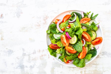 Foto de Ensalada con hojas verdes y verduras. Comida vegana, comida dietética. Vista superior con espacio de copia en la mesa de piedra. - Imagen libre de derechos