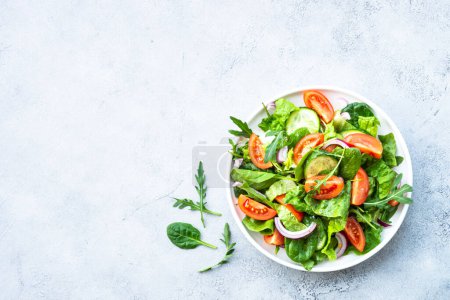 Téléchargez les photos : Salade verte aux feuilles et légumes. Aliments végétaliens, repas diététiques. Vue du dessus avec espace de copie à la table en pierre. - en image libre de droit