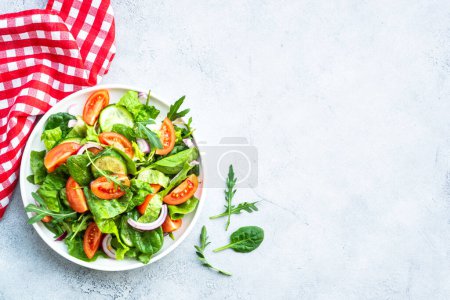 Téléchargez les photos : Salade verte fraîche aux feuilles et légumes. Vue du dessus avec espace de copie à la table en pierre. - en image libre de droit