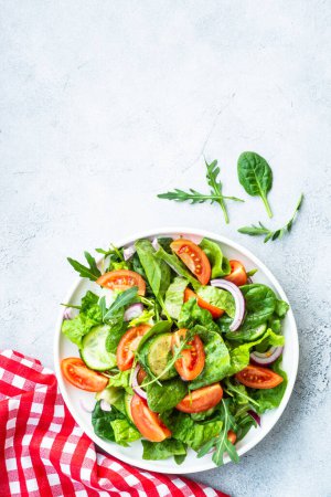 Téléchargez les photos : Salade verte fraîche aux feuilles et légumes. Vue du dessus avec espace de copie à la table en pierre. - en image libre de droit