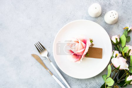 Téléchargez les photos : Table de printemps avec assiette blanche et fleurs roses. Décor de table pour un anniversaire ou un mariage. - en image libre de droit