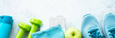Photo for Fitness equipment. Sneakers, dumbbells, towel and green apple. Web banner format. - Royalty Free Image