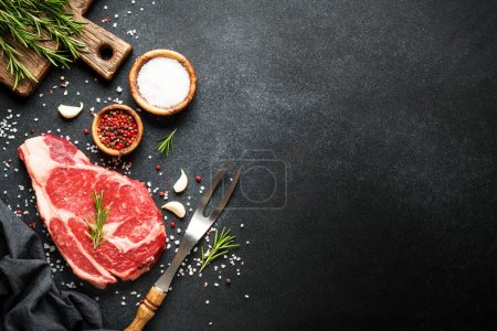 Photo for Meat steak. Beef steak ribeye with spices and herbs on black background. Top view with copy space. - Royalty Free Image
