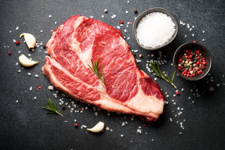 Photo for Beef steak with spices on black background. Ribeye steak raw meat. Top view with copy space. - Royalty Free Image