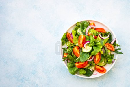 Photo for Salad with green leaves and vegetables. Vegan food, diet meal. Top view with copy space at stone table. - Royalty Free Image
