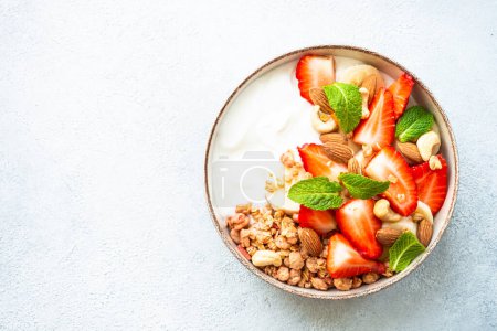 Foto de Yogur con granola y fresas sobre blanco. Snack o desayuno saludable, ensalada de frutas. Vista superior. - Imagen libre de derechos