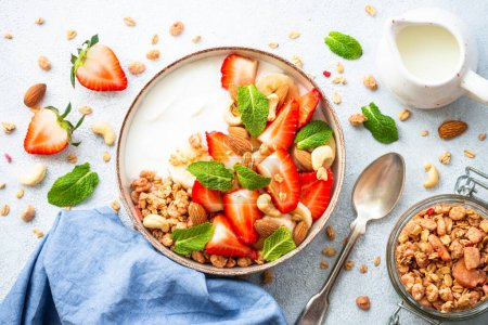 Photo for Yogurt with granola and strawberries on white background. Healthy snack or breakfast. Top view with copy space. - Royalty Free Image