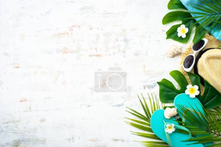 Photo for Summer flat lay background, vacation and travel concept. Palm leaves, hat, flip flop and sunglasses on white. - Royalty Free Image