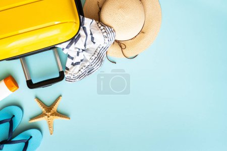 Téléchargez les photos : Voyage fond, vacances d'été. Valise, passeports, chapeau et tissu d'été sur fond bleu. Image de pose plate avec espace de copie. - en image libre de droit