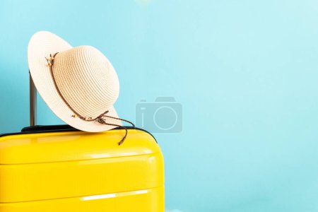 Photo for Summer holidays, traveling concept. Suitcase, hat and flip flops on blue background. - Royalty Free Image