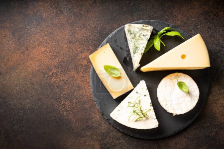 Foto de Bandeja de queso con surtido de queso artesanal en pizarra en la mesa de piedra. Puesta plana. - Imagen libre de derechos