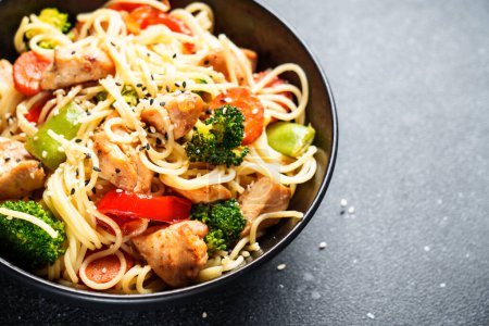 Photo for Stir fry chicken with vegetables and noodles at black background. Asian cuisine. Close up. - Royalty Free Image