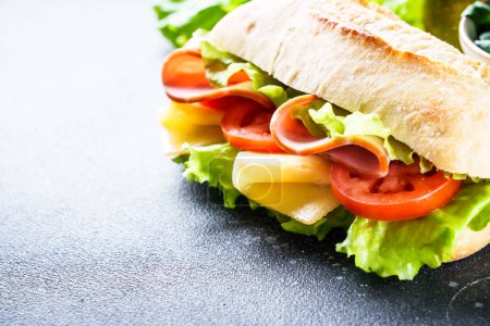 Téléchargez les photos : Sandwich à la laitue, fromage, tomates et jambon. Restauration rapide saine, petit déjeuner ou déjeuner. Gros plan. - en image libre de droit