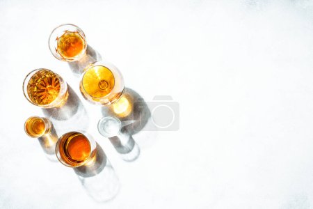 Photo for Strong alcohol drink. Cognac, whisky, rum, tequila at white background. Top view. - Royalty Free Image