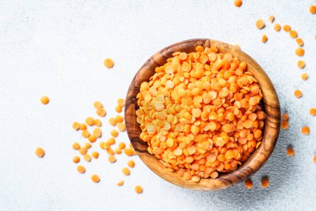 Photo for Red lentils in wooden bowl on white background. Top view. - Royalty Free Image