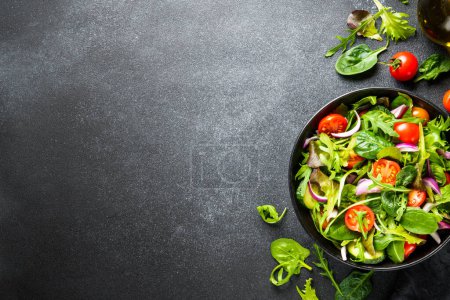 Téléchargez les photos : Salade, nourriture végétalienne à fond sombre. Aliments sains, menu diététique. Vue du dessus. - en image libre de droit