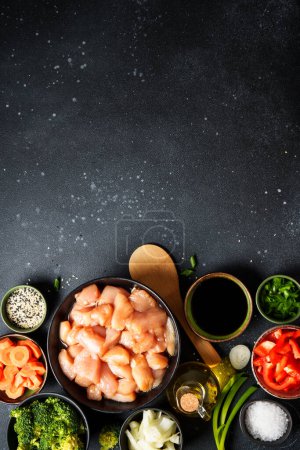 Photo for Chicken stir fry with vegetables cooking ingredients at black background. Flat lay with copy space. - Royalty Free Image