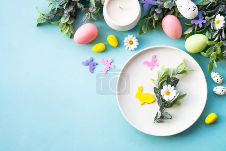 Téléchargez les photos : Table de Pâques, fond alimentaire de Pâques. Assiette blanche avec œufs et décorations de vacances. - en image libre de droit