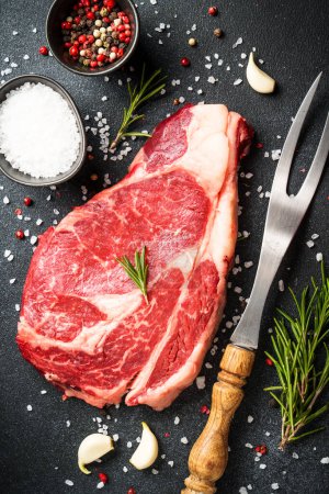 Photo for Meat steak. Beef steak dry aged with spices on black background. Top view. - Royalty Free Image