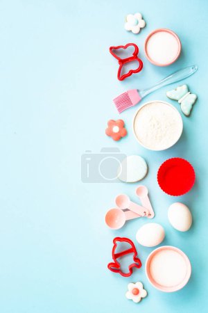 Photo for Easter baking background on blue. Flour, edds, sugar and gingerbread cookies. Top view with copy space. - Royalty Free Image