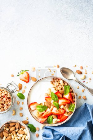 Foto de Yogur con granola y fresas sobre fondo blanco. Snack o desayuno saludable. Vista superior con espacio de copia. - Imagen libre de derechos