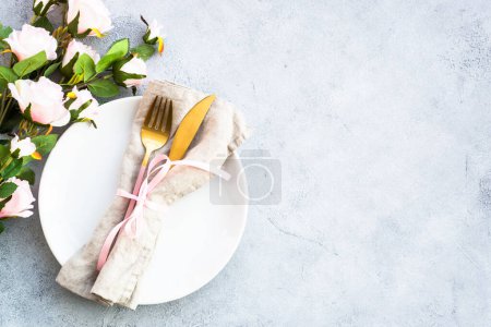Photo for White plate, cutlery and wine glass with pink flowers. Spring table settong. Flat lay with copy space. - Royalty Free Image