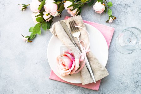 Foto de Placa blanca, cubiertos y copa de vino con flores rosadas. Mesa de primavera Setong. Piso con espacio de copia. - Imagen libre de derechos