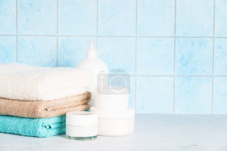 Foto de Cuarto de baño con productos cosméticos y toallas limpias. Productos de belleza, relajación, cuidado de la piel. - Imagen libre de derechos
