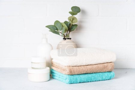 Productos cosméticos y toallas limpias en el baño. Tratamiento de spa y productos de belleza.