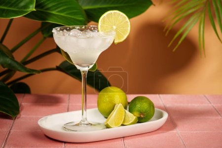 Photo for Margarita, traditional alcoholic cocktail with lime, silver tequila, ice cubes and salt. Pink tropical background with hard shadows. - Royalty Free Image