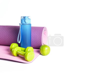 Téléchargez les photos : Tapis de yoga, haltères et bouteille d'eau isolée sur fond blanc. Style de vie sain, concept de fitness et yoga. - en image libre de droit